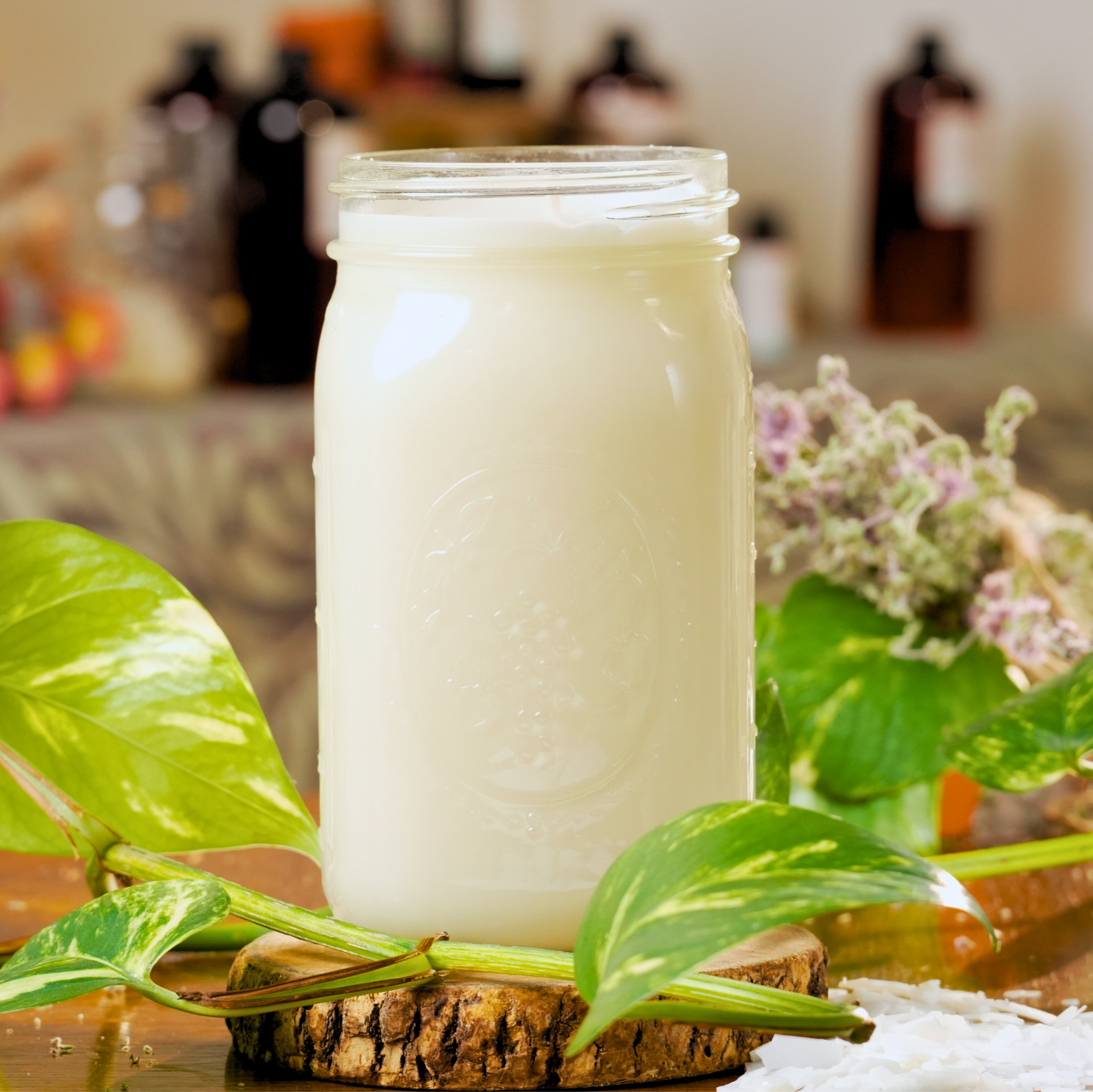 Mason jar filled with white hardened candle wax on a wooden coaster with leaves in the foreground.