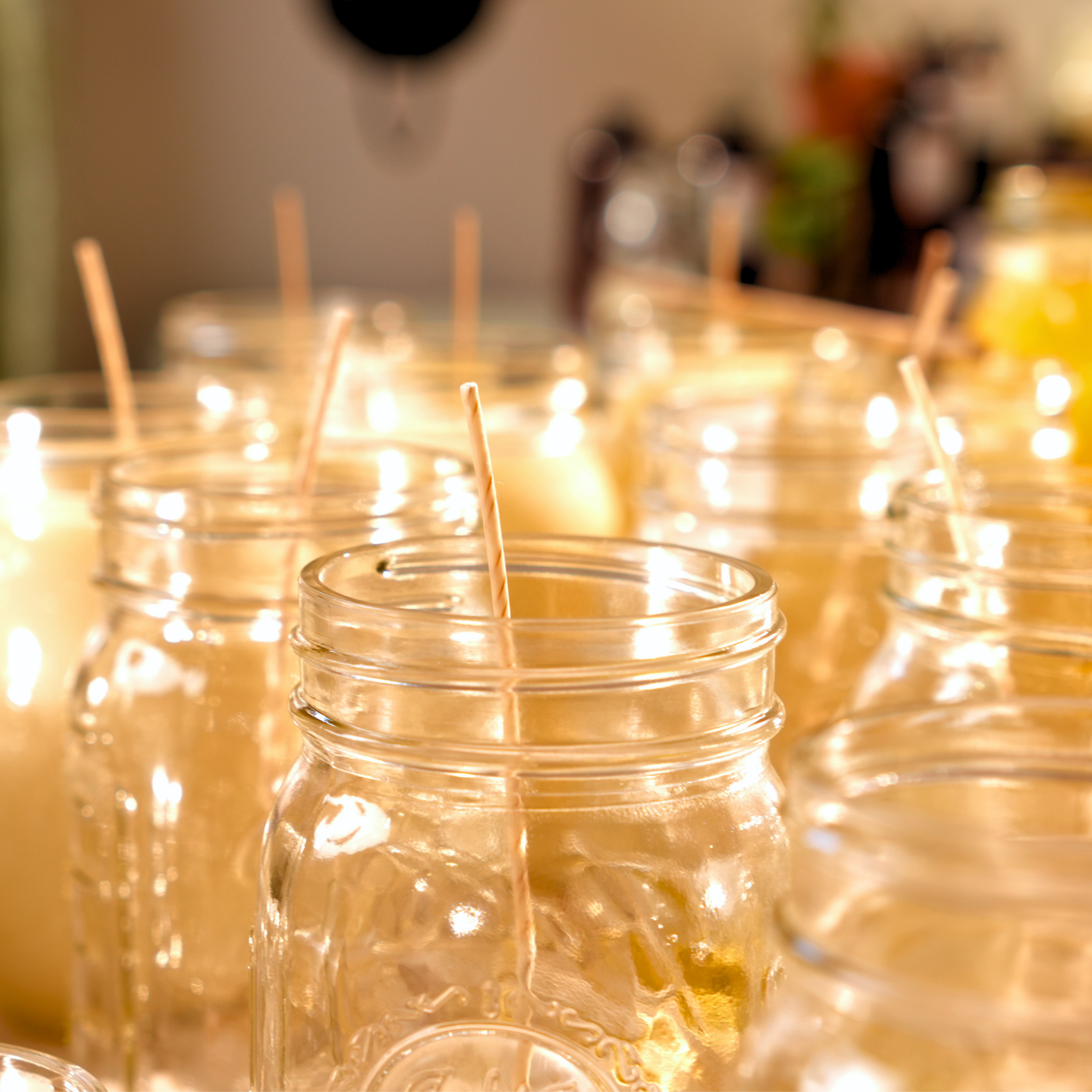 Glass jars with candles on a table, blurred background